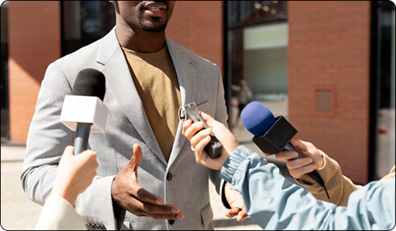 Black man being interviewed by reporters with microphones